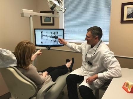 dentist helping patient in office