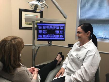 dentist helping patient in office